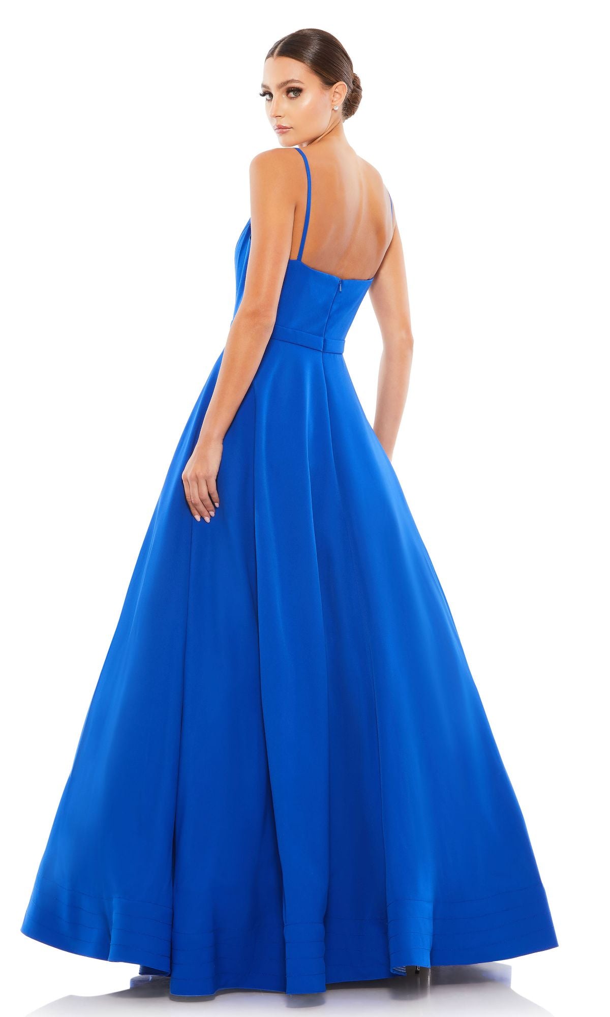 A woman wearing the Mac Duggal 48855 Classic Long A-Line Formal Dress in bright blue stands facing away, looking over her shoulder against a plain white background.